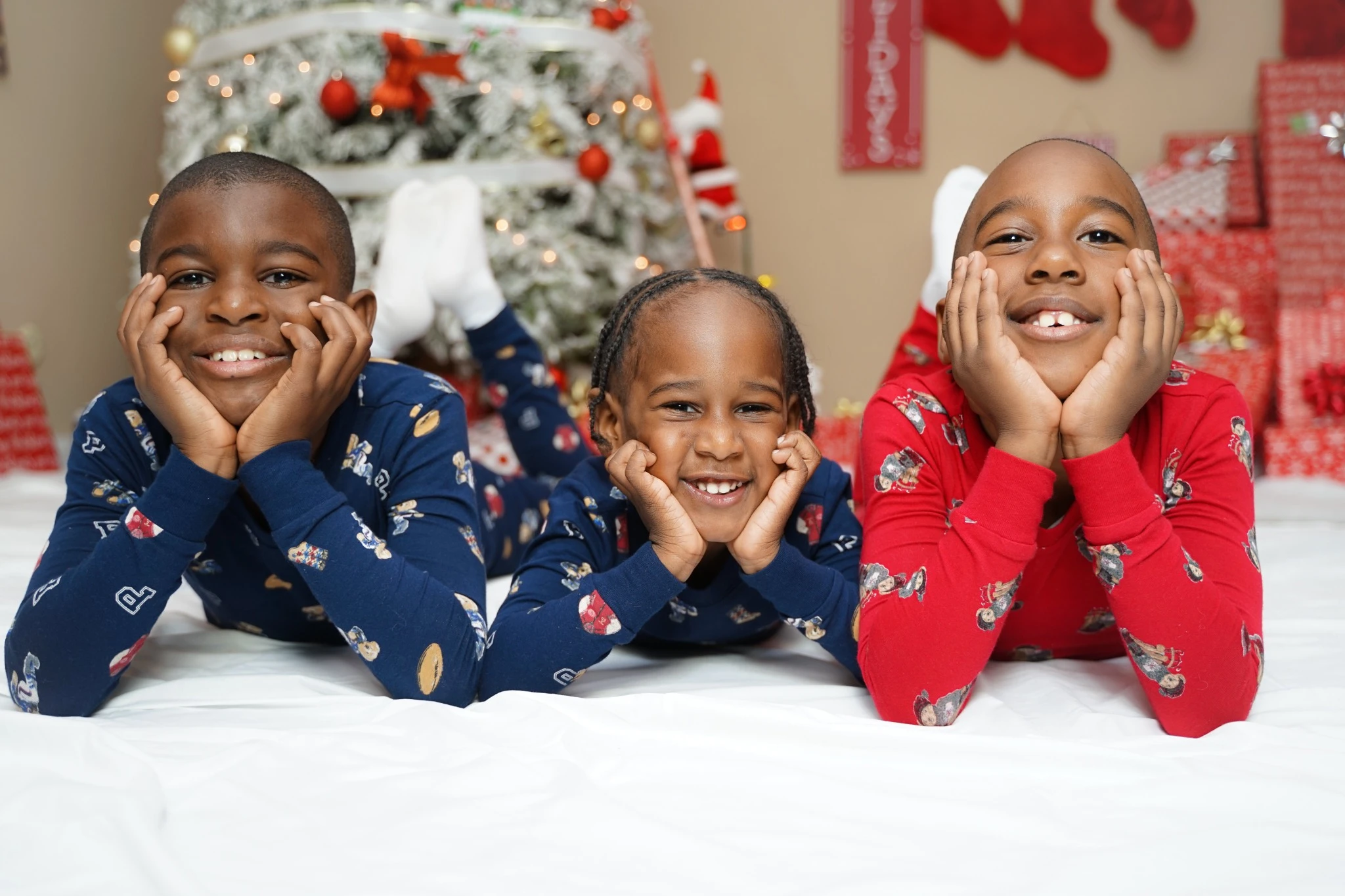 Three smiling children in holiday pajamas