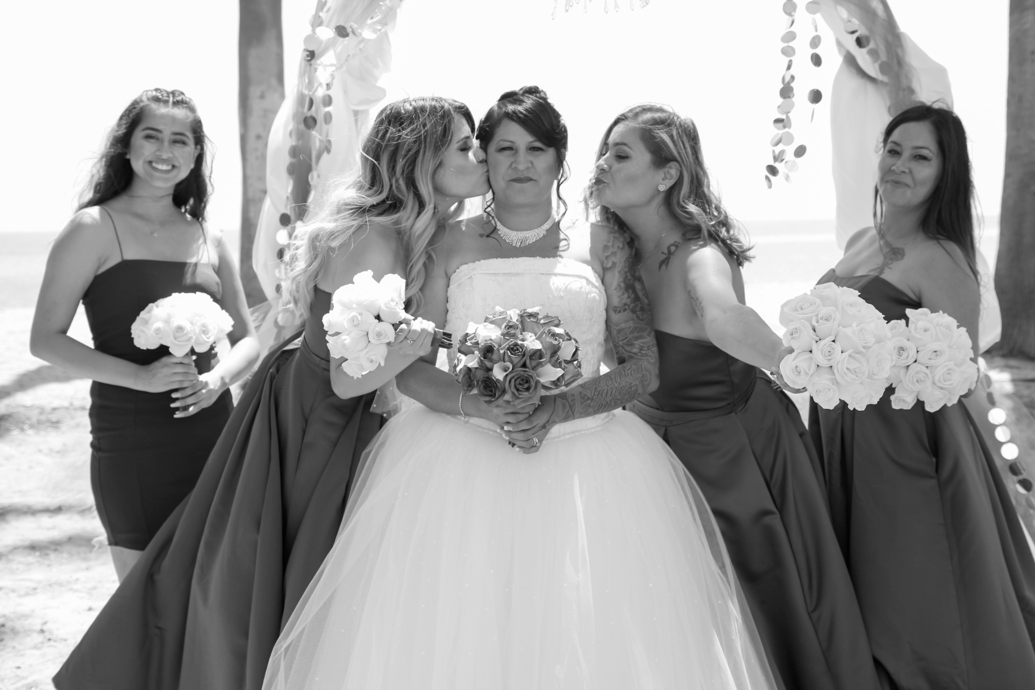 The bride celebrating with her bridesmaids and their bouquets